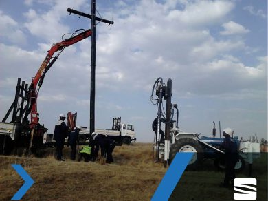 Crane truck and crew replacing a wooden pole on a rural distribution line.