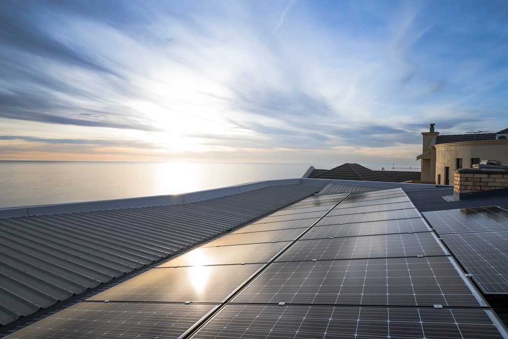 A rooftop photovoltaic array catching low sun.