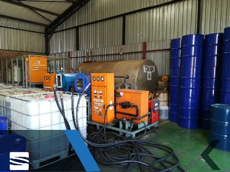 Transformer oil regeneration plant with storage drums inside a workshop.
